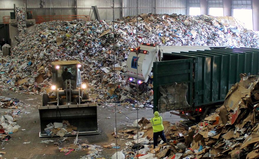 Trucks dump their loads of single-stream recycling on the "tip floor" at Resource Management's Materials Recovery Facility (MRF) in Earth City, Mo.