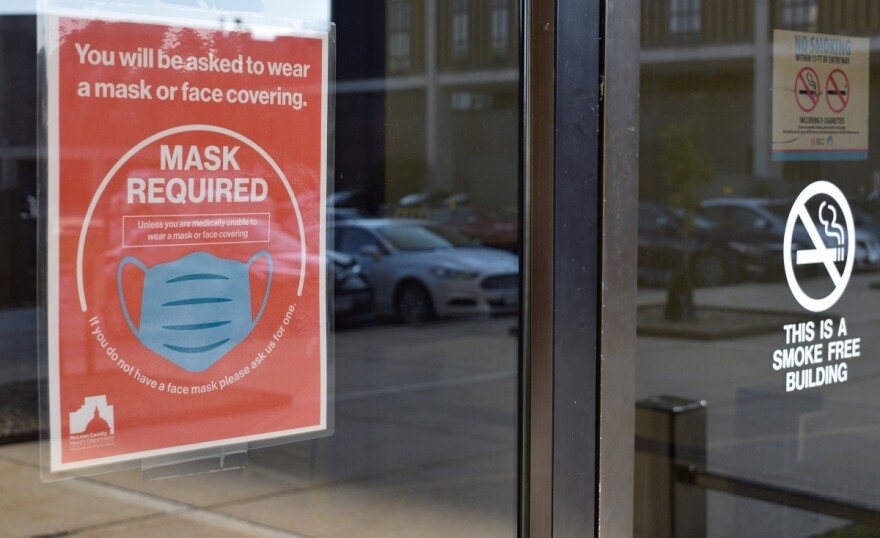 A sign at the entrance to the McLean County Health Department building requires all entrants to wear a face mask.