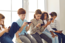 Five children play on cellphones