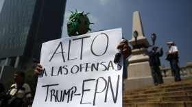 Diego Garcia wears a Mexican wrestling mask and holds a sign reading in Spanish; "Stop the offenses of Trump and EPN," referring to Mexican President Enrique Pena Nieto, as he protests Donald Trump's meeting with the president, in Mexico City, Wednesday, Aug. 31, 2016. (Rebecca Blackwell/AP)