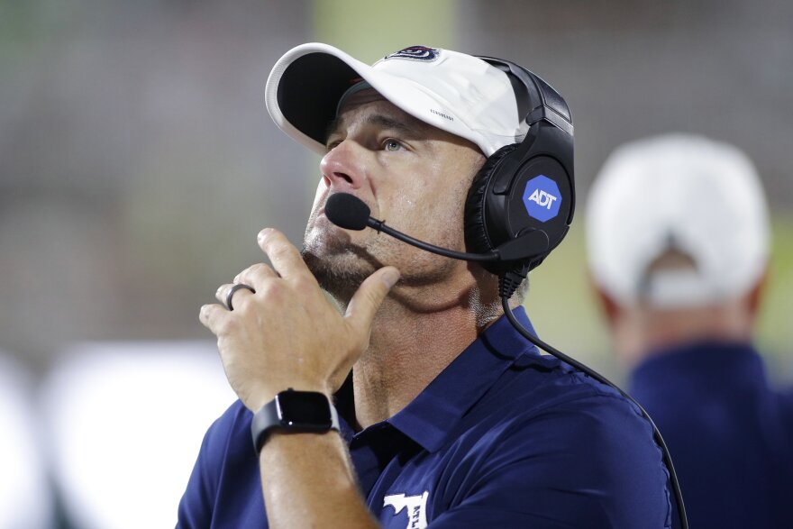 A coach watches the fourth quarter of a football game