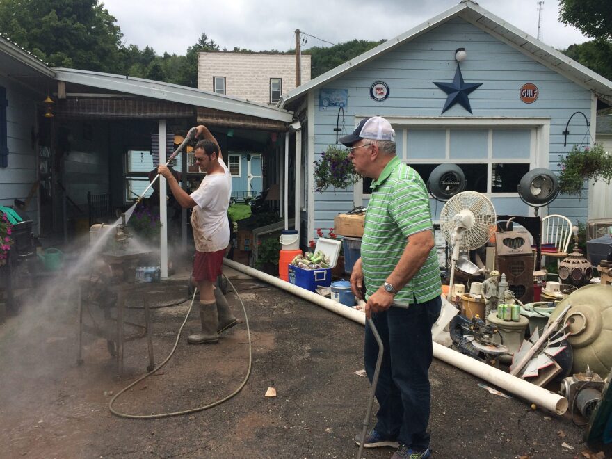 Peter Bryan powerwashes what he could salvage from his "mancave" in the basement - including an antique saw and model cars.