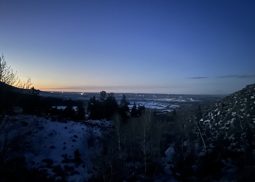  A sunrise skyline with lights in the distance.