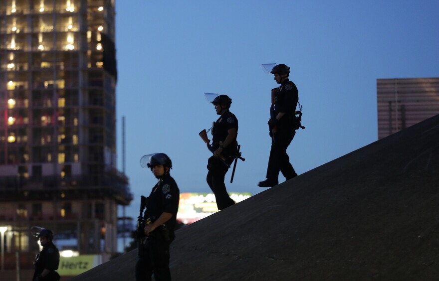 FILE - Austin police keep watch as demonstrators gather on June 4, 2020, in downtown Austin, Texas, as they protest the death of George Floyd, a black man who died after being restrained by Minneapolis police officers on Memorial Day. The Austin City Council on Thursday, Feb. 17, 2022, approved paying a combined $10 million to two people injured when officers fired beanbag rounds into crowds during the 2020 social justice protests, including a college student who suffered brain damage.