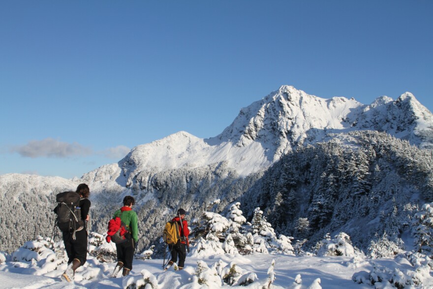 From left: Cora Siebert, Jacquie Foss and Aaron Prussian hike the ridge to the landslide monitoring station in November 2019. Over the summer, Sitka’s Search and Rescue team helped pack in hundreds of pounds of components along this narrow trail. (Ari Snider/KCAW)