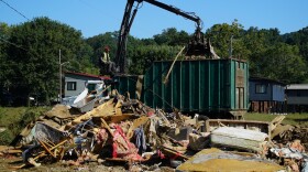 A claw operator scoops up debris from homes demolished following Hurricane Helene in Old Fort, N.C., on Thursday, Sept. 11, 2025.