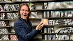 Composer Eric Whitacre in the WUOL music library posing with a CD