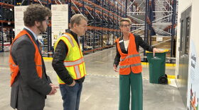 Erin Pulling, right, CEO of Food Bank of the Rockies, talks to U.S. Sen. Michael Bennet, middle, and Ron Meehan, government relations manager for Feeding Colorado in a large warehouse.