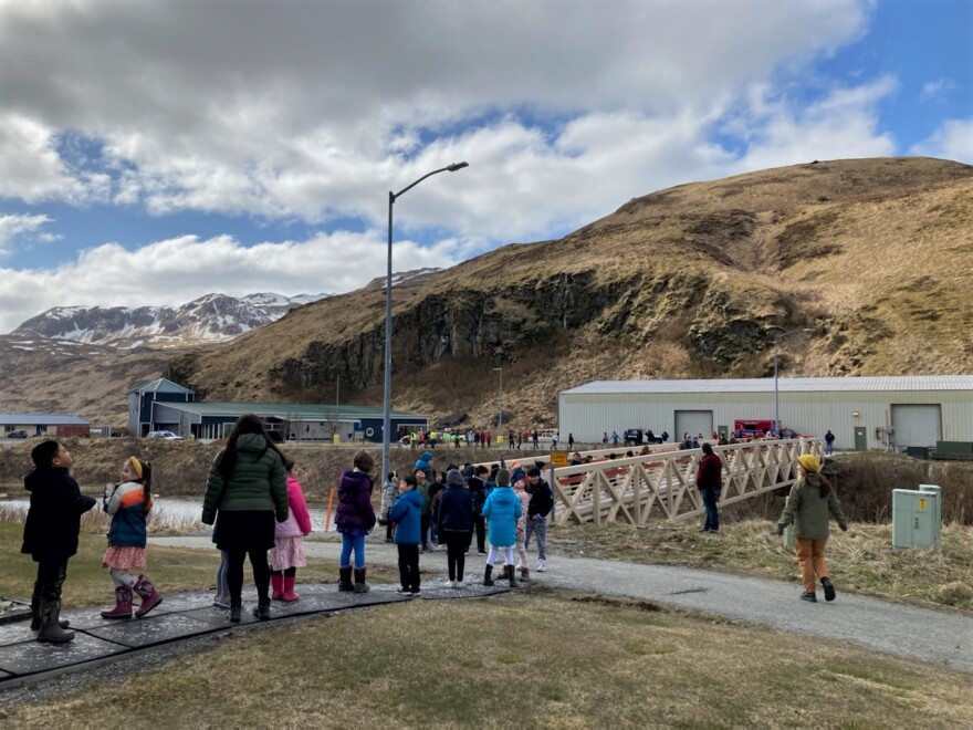 Unalaskans form a human chain to help move books into the newly renovated Unalaska Public Library on Wednesday, April 19, 2023.