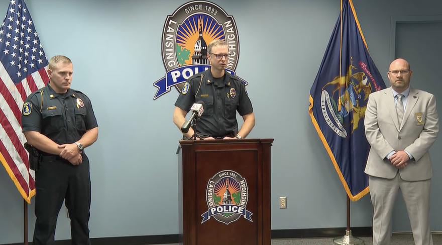 Lansing Police Chief Rob Backus in the middle talking. 