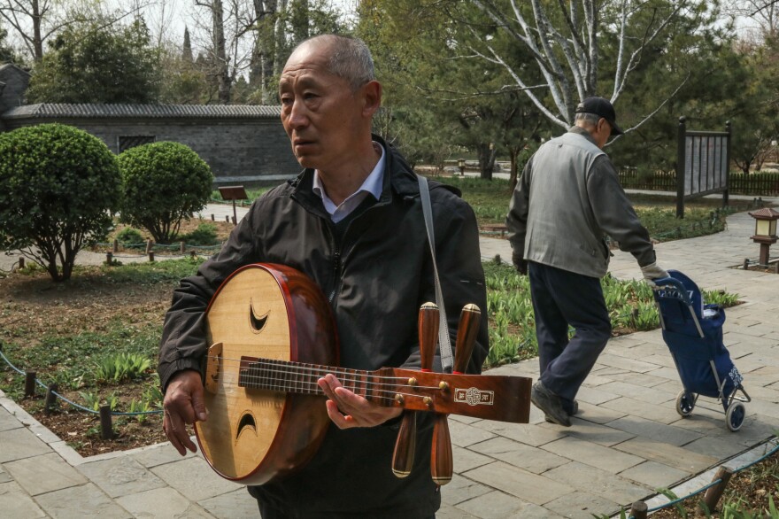 Yang Jiancheng, 63, taught himself to play the <em>ruan</em>, a four-stringed, mandolin-like instrument.