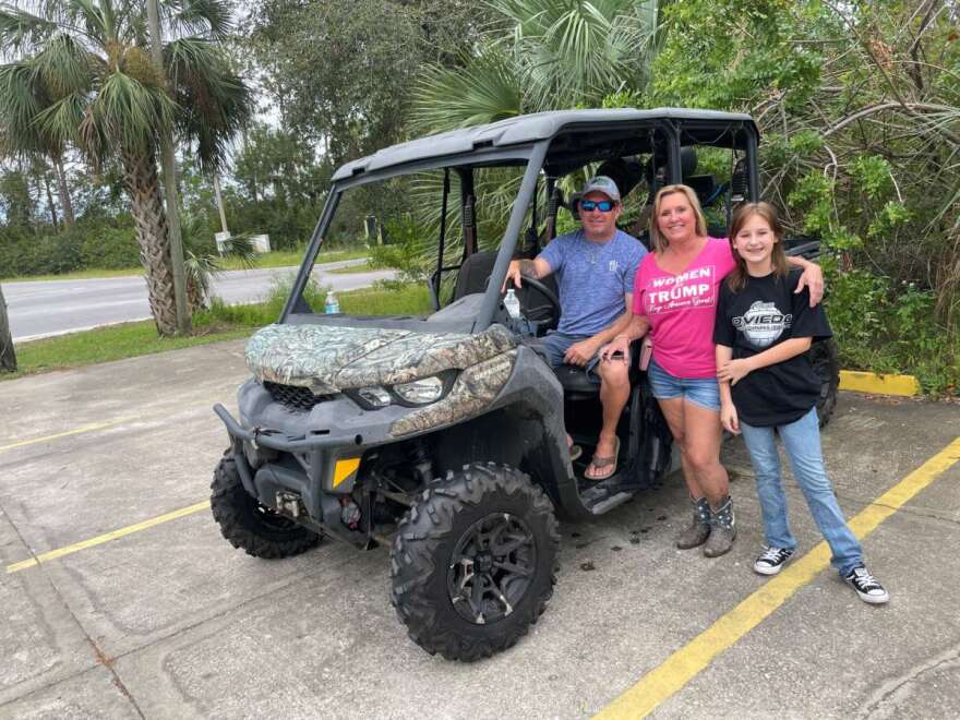 Man, woman and girl posing on an ATV