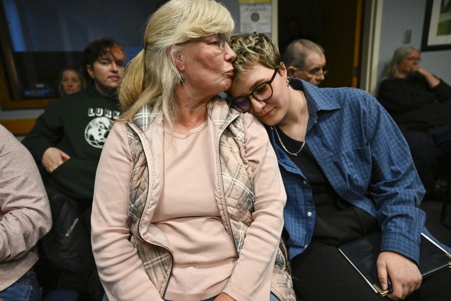 Ivy Ross (left) kisses her daughter Emily Ross after the two addressed the Killingly School Board of Education at a board meeting April 28. Emily said during testimony she endured regular bullying in high school due to her sexual orientation. “I have an emotionally literate parent and I did not tell her,” she said, “I feel safe with her and I still did not tell her. And I think that’s why it hurts so much to watch you debate this topic,” she told the board. “We know this isn’t a question of morality,” said Ross, “Because we know that if a child or a high school student came to you and asked for help and said they wanted to take their own life, you would not ask, ‘well, how much would it cost?’ or ‘is your parent aware of the services you are seeking?’ You would help.”