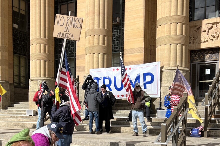 Supporters of President Trump stand on the steps of Buffalo's City Hall near the No King's rally on Saturday, March 28, 2026. 