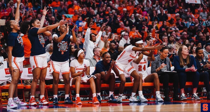 Syracuse’s bench in an uproar after a three-point shot made by Georgia Woolley.