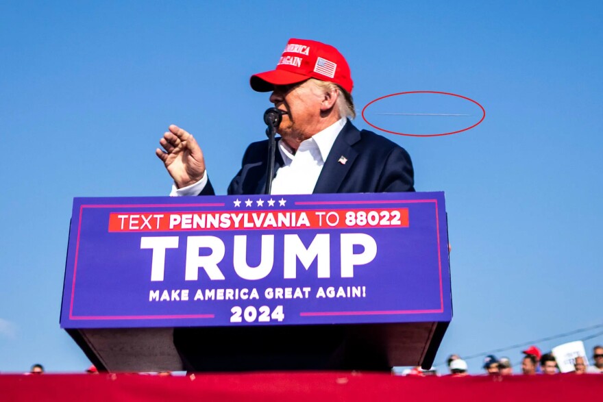 An annotated photo showing what appears to be a projectile passing by Donald J. Trump during a rally in Butler, Pa., on Saturday, July 13, 2024. Michael Harrigan, a retired F.B.I. special agent, said during an interview that this image captured by Doug Mills, a New York Times photographer, seemed to show a bullet streaking past the former president during a campaign rally in Butler on Saturday.