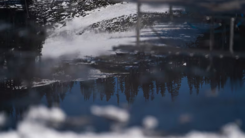 Reflected in a pool of melting ice, dirt and grass show through the low snowpack at Mt. Hood Meadows on the resort’s second-to-last weekend in Mt. Hood, Ore., on April 4, 2026.