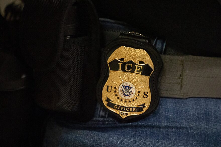 A U.S. Immigration and Customs Enforcement badge on a belt