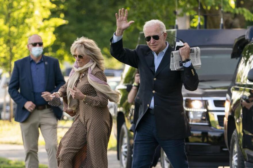 President Joe Biden waves as he walks with first lady Jill Biden to board Marine One.