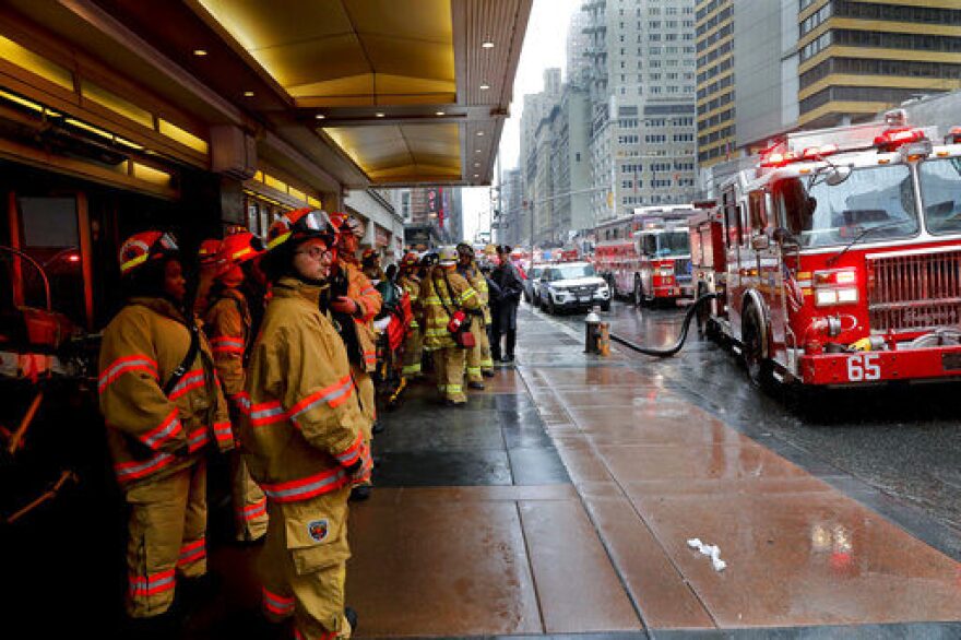 Firefighters respond to the scene where a helicopter crash-landed on the roof of a midtown Manhattan skyscraper, Monday, June 10, 2019, in New York. (AP Photo/Mark Lennihan)