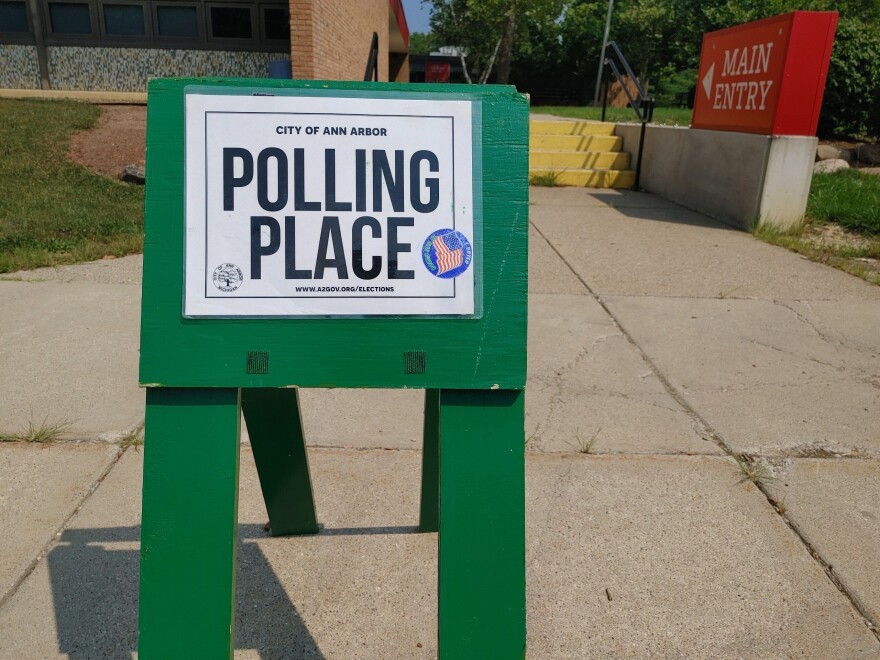 vote here and polling place signs line a street in Ann Arbor, Michigan