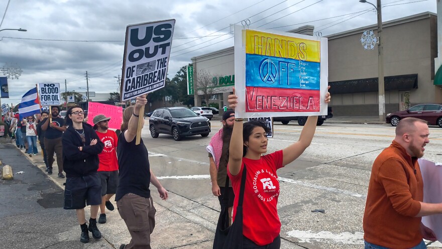 People march through Orlando’s Mills 50 neighborhood on Saturday in protest of the United States’ military intervention in Venezuela.