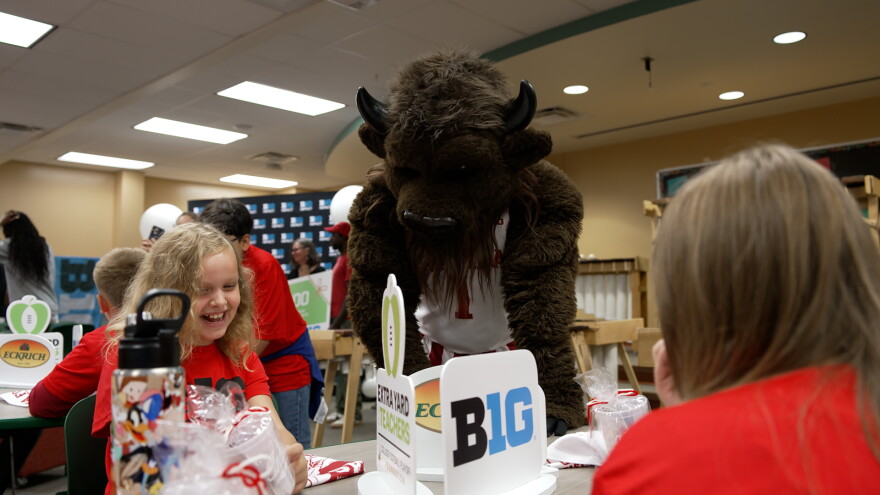 A bison mascot interacts with elementary school kids.