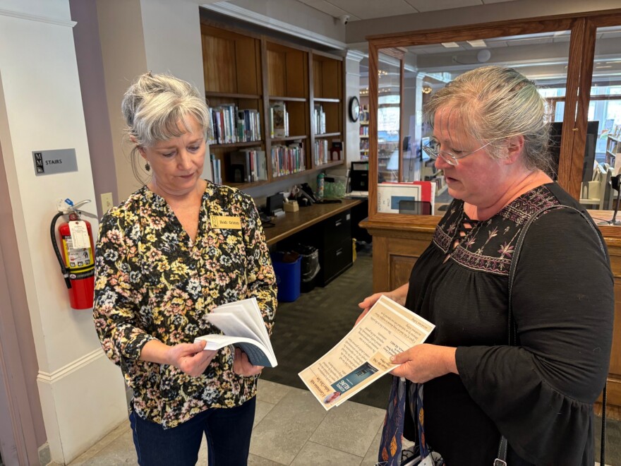 Karen McKenna the new book "Accidental Killing" to Yarmouth librarian Heidi Grimm.