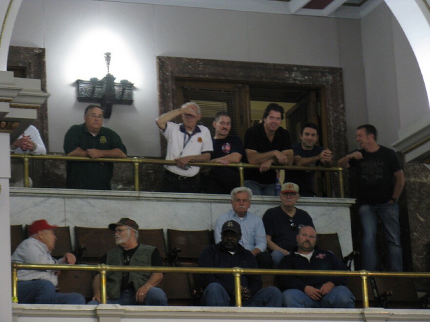 Current and retired firefighters watch the Board of Aldermen debate reforms to their pension system on April 16, 2012.