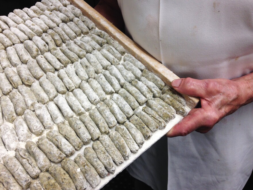 Clemente Cittoni holds a tray of malfatti.