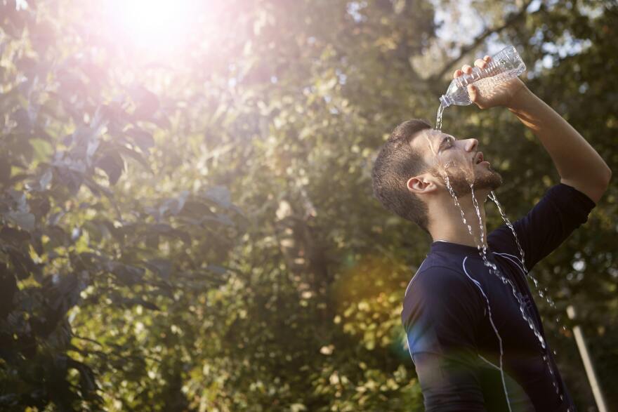 A man pouring water onto his fac