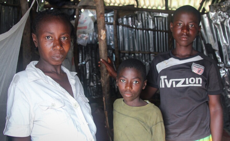 Bintu Tarawaly with sons Clifford, 9, and Sahr, 14. With his dad out of the picture, Sahr is working to support the family.