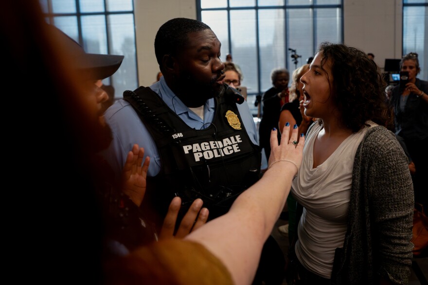 “Rizing,” a south St. Louis demonstrator, attempts to ration with police after they attempted to remove her during a town hall held by U.S. Rep. Wesley Bell, D-St. Louis County, at The Post Building on Tuesday, Aug. 19, 2025, in downtown St. Louis.