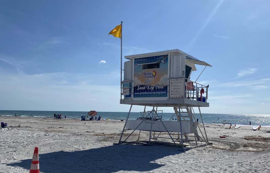 Beach with lifeguard seat with Sand Key Park sign 