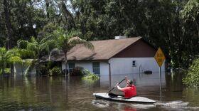 Man kayaks back to his Valrico home for more belongings, in flood waters from the Alafia River, after Hurricane Irma in September 2017. 