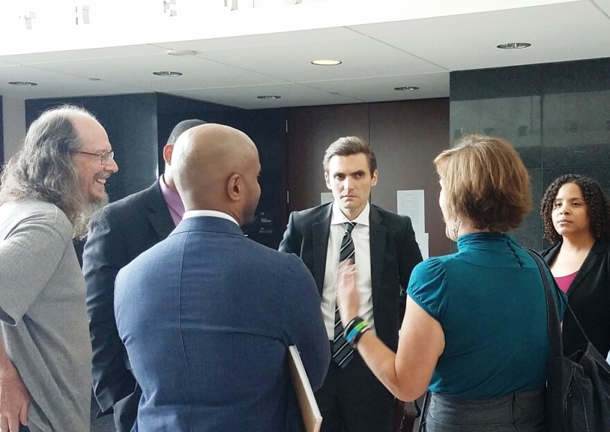 U.S. Department of Justice attorney Jude Volek, center, listens to activists in the Ferguson community June 22, 2017 after an update on the progress Ferguson is making on mandated changes to its police and courts.