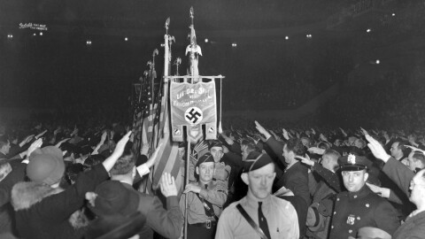 FILE - The crowd responds with a Hitler salute as uniformed members of a German-American Bund color guard march at a gathering in New York's Madison Square Garden, Feb. 20, 1939. (AP Photo/File)