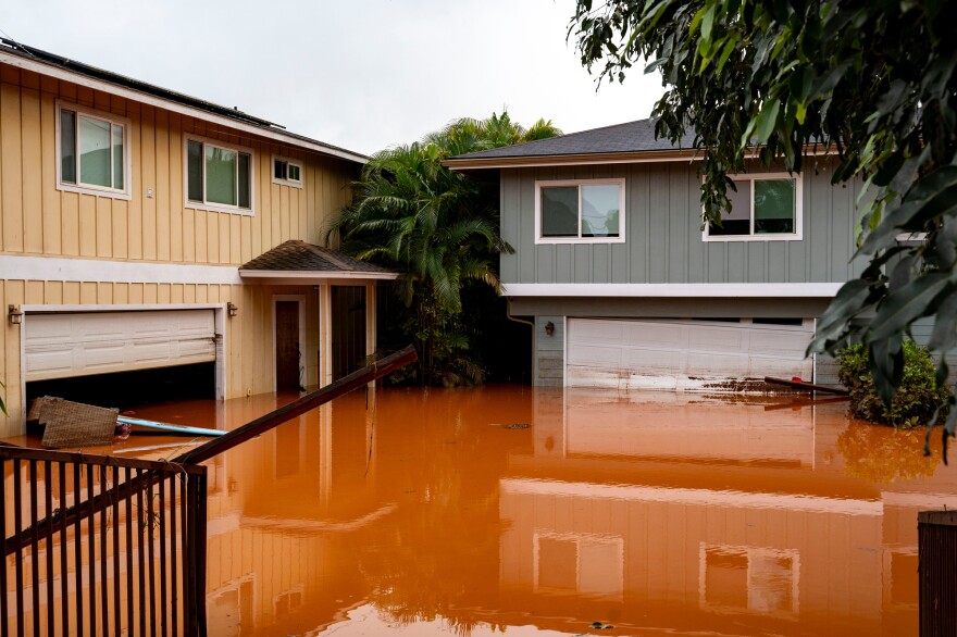 Floodwaters fill the ground level of homes in Waialua, Hawaii, Friday, March 20, 2026. (AP Photo/Mengshin Lin)
