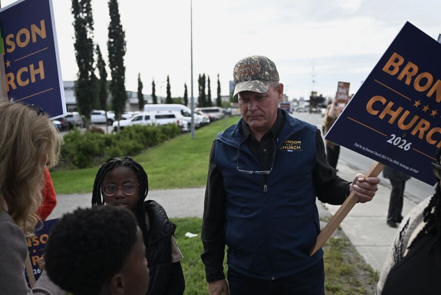 Republican gubernatorial candidate Dave Bronson, right, holds a campaign sign on Aug. 18, 2026.