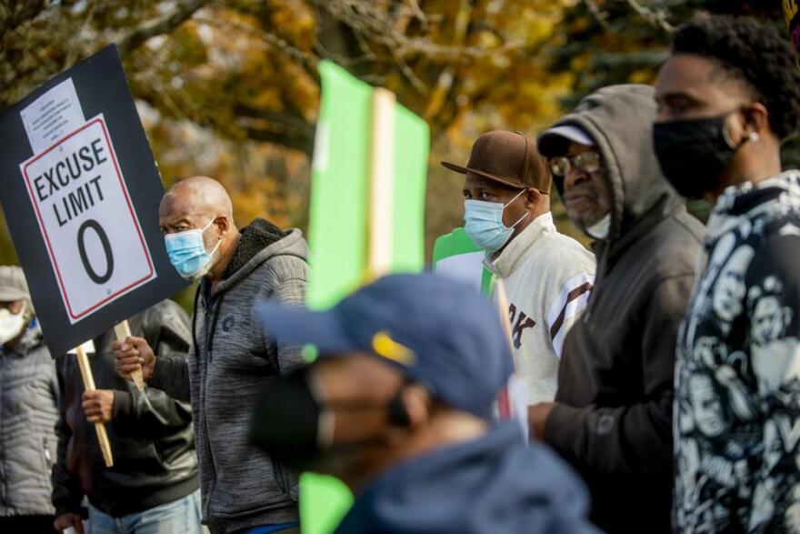 Flint residents Sherman Williams, left, and Johnny Brown, center right, protest alongside more than a dozen others calling for the resignation of Treasurer Gayle Armstrong on Thursday, Nov. 4, 2021, outside the Mount Morris Township, Mich., offices. MLive-The Flint Journal says Armstrong told the newspaper she called township Chief Financial Officer Greg Eason a “boy” during a conversation with township Supervisor Jolena Sims. Armstrong, who is white, said it wasn’t meant as a racial slur