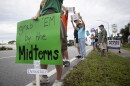 People gather along U.S. 41 in Fort Myers on Saturday morning, October 17, 2026, to advocate for change ahead of the mid-term elections. Organizers estimate about 1,000 people came out for the event.
