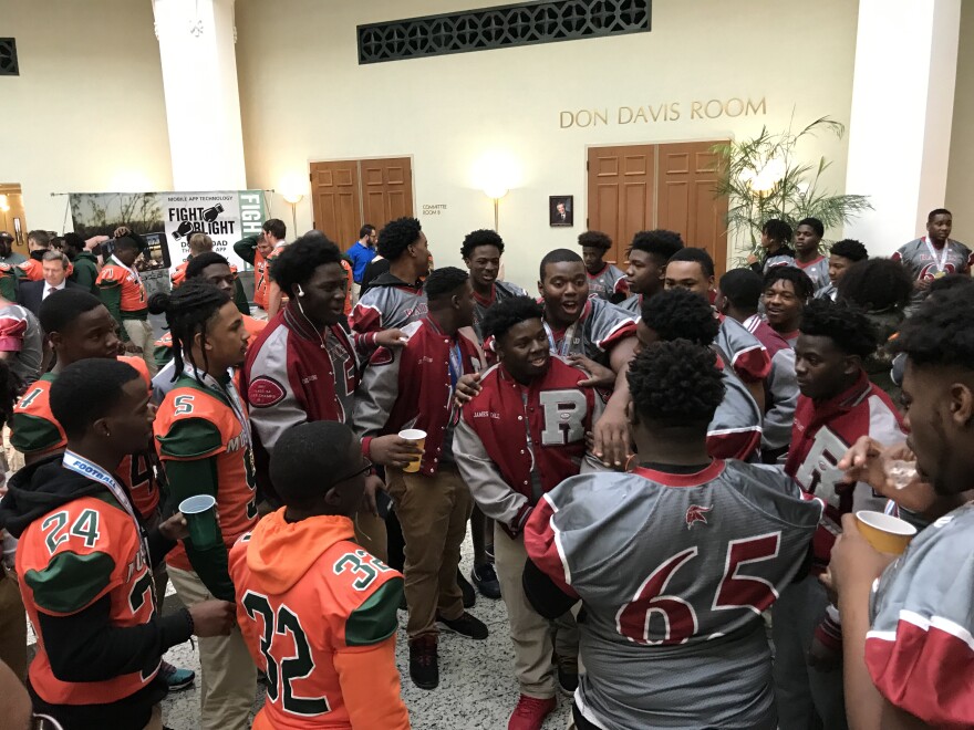 Players from Mandarin and Raines High Schools celebrating together at Jacksonville City Hall.