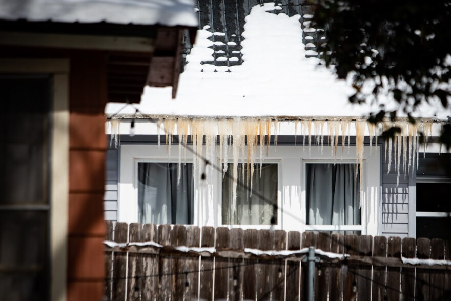 Icicles hang from a roof. 