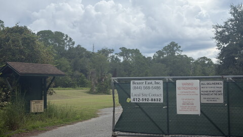 A gate blocks the entrance to the Koppers property in Gainesville, Florida, on Sept. 11, 2026. Signs at the entrance identify Beazer East Inc. and warn visitors that the property is a contaminated area.
