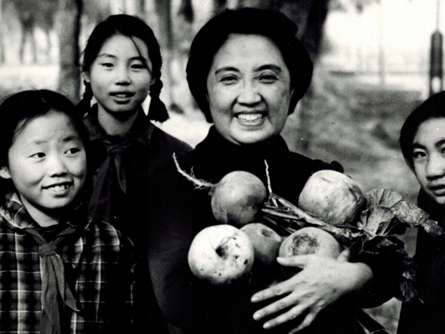 Joyce Chen (center) holds large Chinese radishes picked by middle-school students in Beijing, China, in 1972.