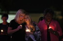Woman hold lit candles at vigil