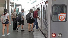 Airport passengers and commuters board the Metrorail at Miami International Airport.