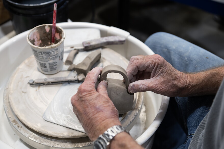 Art Lloyd prepares to add a handle to the mug he is working on. The new 18,600-square-foot facility accommodates more students, artists and private studio renters