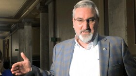 Indiana Gov. Eric Holcomb speaks with reporters at the Indiana Statehouse in Indianapolis on Wednesday, Feb. 23, 2022. The Republican governor signaled support for contentious proposals moving through the Legislature that would ban transgender girls from participating in K-12 girls school sports and would place restrictions on teaching about racism and political topics.