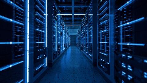 An artistic photo showing a row full of data servers with soft blue light